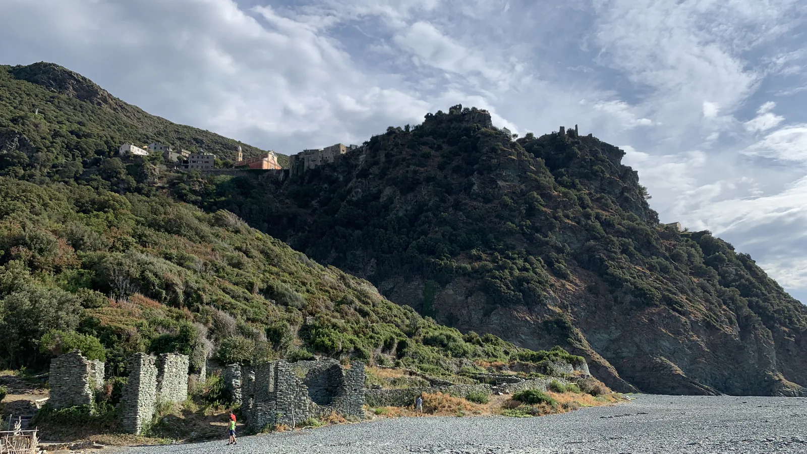 Plage noire de Nonza au premier plan et village perché sur la falaise