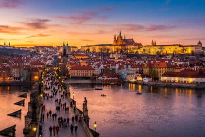 Vue aérienne de Prague au crépuscule. Le Pont Charles animé, le Château de Prague illuminé et la rivière Vltava.