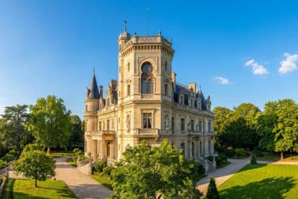 Façade ensoleillée du château de Monte-Cristo, ancienne demeure d'Alexandre Dumas, entourée d'un jardin luxuriant.