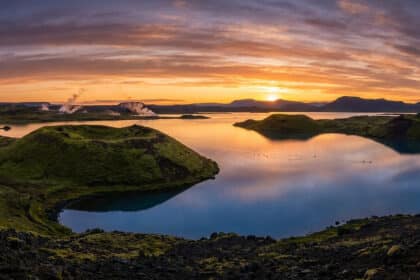 Paysage panoramique du lac Mývatn en Islande avec ses cratères volcaniques et ses fumerolles au coucher du soleil.