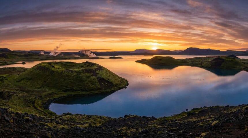 Paysage panoramique du lac Mývatn en Islande avec ses cratères volcaniques et ses fumerolles au coucher du soleil.