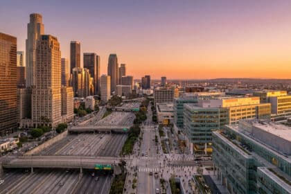 Vue aérienne du centre-ville de Los Angeles avec ses gratte-ciel et son autoroute au coucher du soleil.