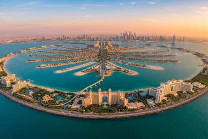 Vue aérienne grand angle de Palm Jumeirah en forme de palmier à Dubaï lors d'un coucher de soleil doré.